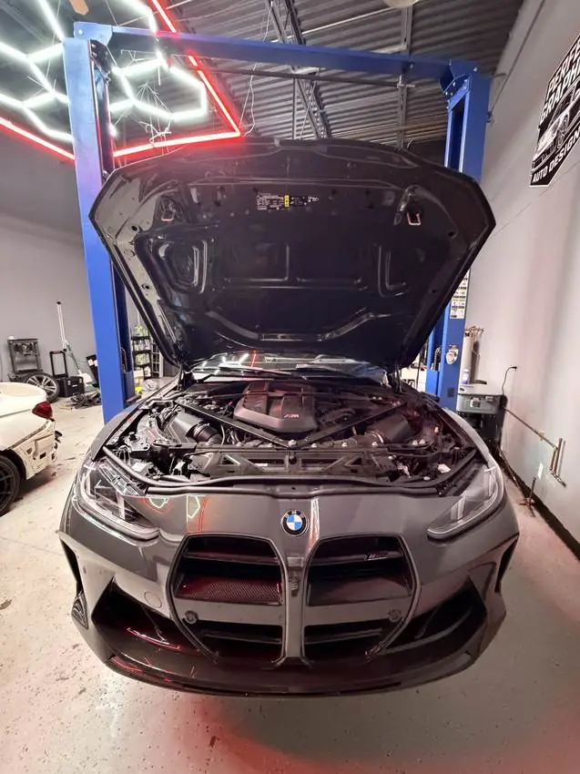 BMW M4 on the lift under hex lighting inside PRM Eurowerks, Cary IL
